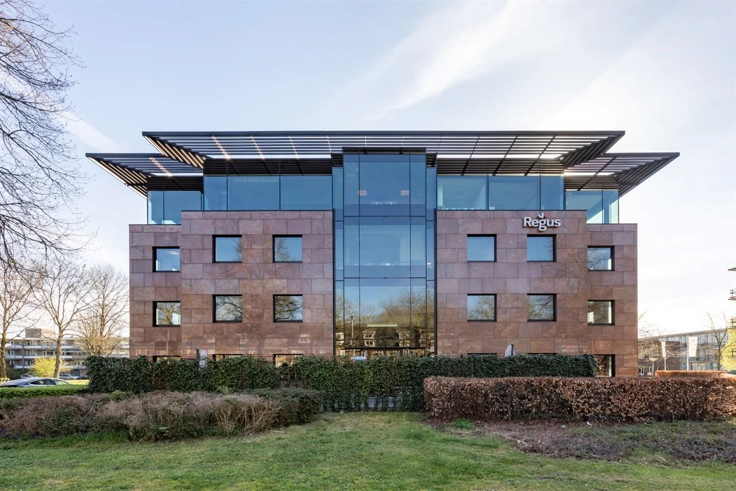 Modern kantoorgebouw aan de De Cuserstraat in Amsterdam met Regus-logo op de gevel.